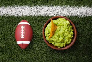 Balón de fútbol americano junto a un plato de guacamole que ilustra el mercado estadounidense del que habla Luis Doporto Alejandre