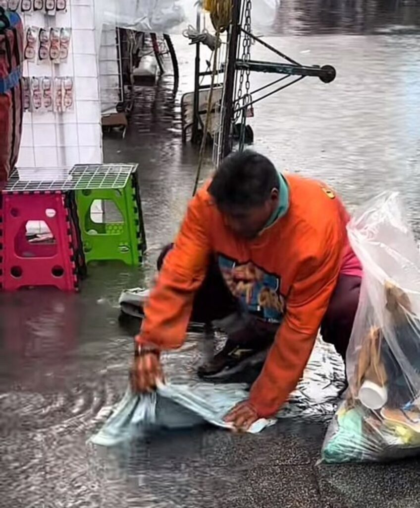Hombre lava su ropa con agua de lluvia en calles de CDMX