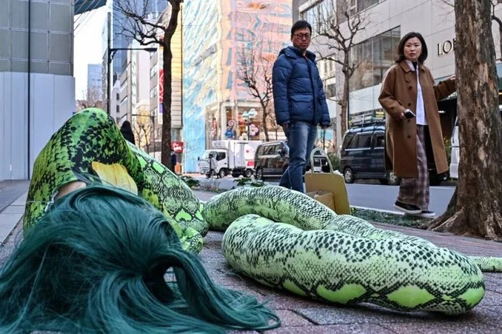 Activista de PETA vestida de serpiente se manifestó en tienda Gucci