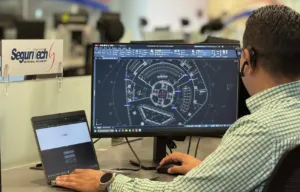 Especialista de Seguritech Privada supervisa un centro de monitoreo con pantallas de análisis de datos e IA para ciberseguridad.
